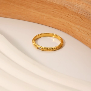 Irregular textured titanium steel ring plated with 18K gold and a square zircon