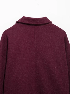 Macro detail of wine red wool coat collar and textured fabric back on white background