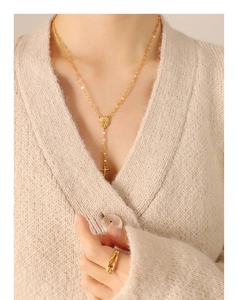 Retro geometric medallion and cross pendant necklace with gold ring on a model