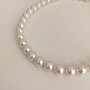 Macro detail of elegant 925 silver pearl necklace showing smooth round beads texture
