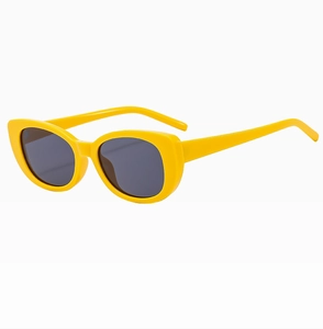 Side view of yellow oval sunglasses with dark lenses on a clean white background