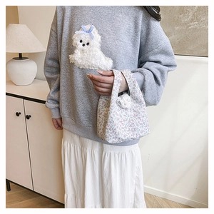Detailed view of floral canvas handbag styled with casual grey sweatshirt and white skirt