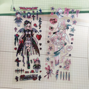 Detail of cartoon stickers with dark gothic and sweet Lolita characters on grid paper