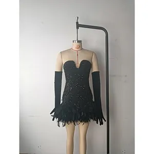 Macro shot of shimmering black sequins and fluffy feather trim on a cocktail dress