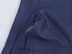 Vue macro de la poche latérale d'une robe bleu marine avec texture de tissu sergé