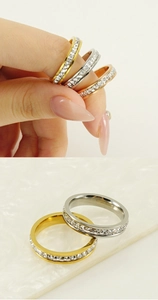 Detail of stacked zircon rings in gold and silver finish on textured stone