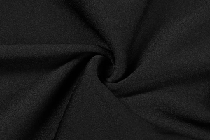 Macro di tessuto a maglia nero morbido con piega a spirale che mostra la qualità premium