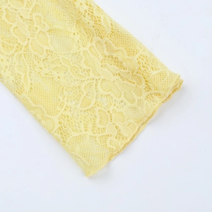 Detail of delicate yellow lace sleeve with intricate hollow pattern for autumn dress