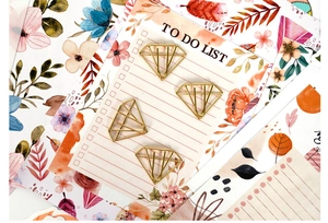 Golden diamond-shaped metal paperclip on To-Do List stationary paper for scrapbooking