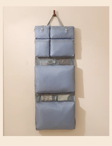 Macro view of a grey multi-layer hanging travel organizer with zippered mesh pockets