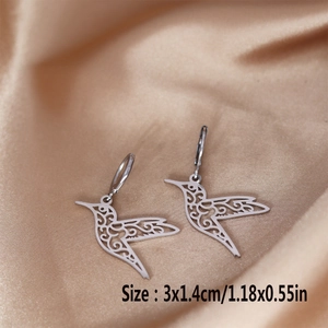 Detailed close-up of hummingbird earrings in silver steel on champagne silk