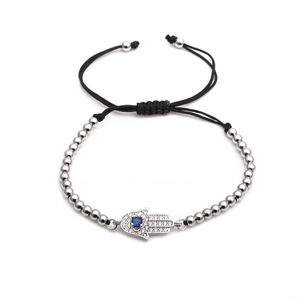 Detail of silver Hamsa Hand charm bracelet with blue stone on black braided cord