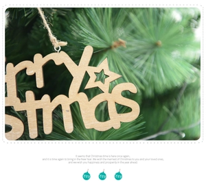 Close-up of wooden Merry Christmas ornament with hollow lettering on pine needles