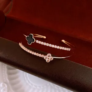 Elegant gold double-layered open bangles with zircon four-leaf clover charms in black and clear