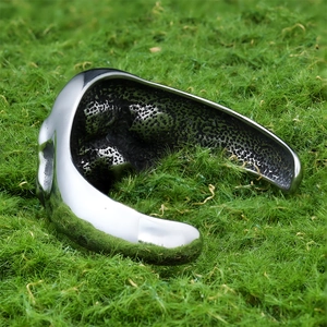 Gothic stainless steel skull bangle with polished exterior and honeycomb interior texture