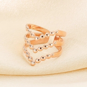 Macro view of rose gold multi-layer V-shape ring with bead design on silk