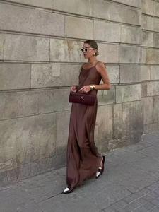 Full length shot of coffee brown satin maxi dress with thin straps on street
