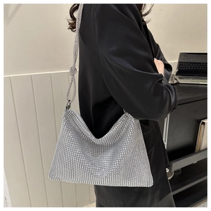 Close-up of sparkling silver rhinestone shoulder bag with knotted strap detail