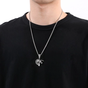Close-up of a vintage silver unicorn pendant necklace worn on a black t-shirt