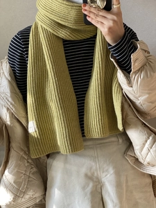 Detail of yellow-green knitted scarf with thick ribbed texture for winter warmth
