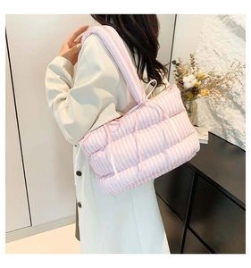 Gros plan d'un sac cabas matelassé à rayures roses avec détail de nœud pour un look chic