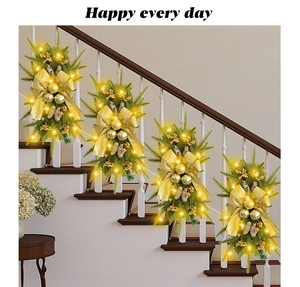 Modern Christmas teardrop swag with golden bows and LED lights on a white staircase