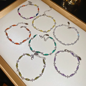 Macro view of colorful marquise-cut zircon bracelets on a white luxury display tray