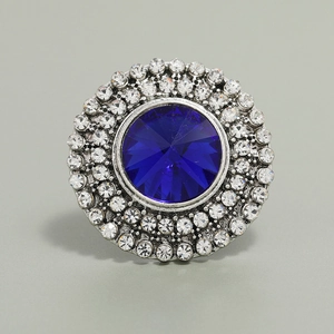 Detailed close-up of a vintage round ring featuring a deep blue crystal and white rhinestones
