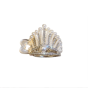 Golden crown hair clip with white pearls and sparkling rhinestones on white background