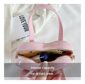 Close-up of pink heart-shaped jelly bag showing internal capacity with lipstick