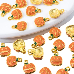Macro detail of Halloween pumpkin charms with orange enamel and gold alloy for DIY jewelry