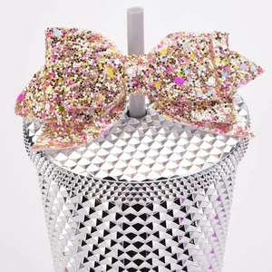 Close-up of glitter bow accessory on a diamond texture silver tumbler with straw