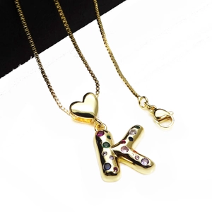 Detailed shot of gold plated K letter pendant with colorful cubic zirconia and heart link
