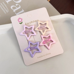 Star-shaped hair clips in cream colors set on decorative tray for styling