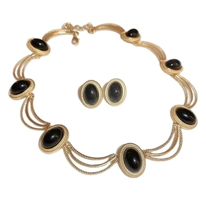 Vintage gold necklace and earrings set with oval black gemstones and woven texture
