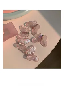 Vue détaillée de cinq pinces à cheveux papillon rose translucide à effet iridescent