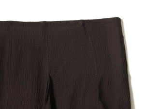 Gros plan détaillé sur le tissu plissé marron foncé et les finitions de la taille