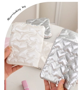 Detailed view of cute heart-shaped quilted passport holders in white and silver colors.
