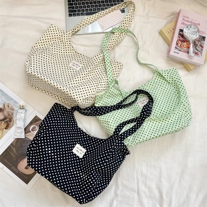 Detailed overhead view of three colorful polka dot canvas tote bags on a lifestyle background