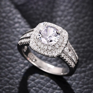Macro-opname van zilveren ring met grote solitaire en dubbele vierkante pavé-zetting
