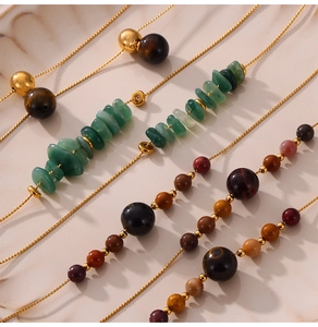 Detailed close-up of handmade beaded necklaces with natural stones on marble background