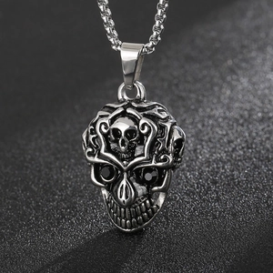 Macro shot of silver skull pendant with intricate relief texture and black gemstone eyes
