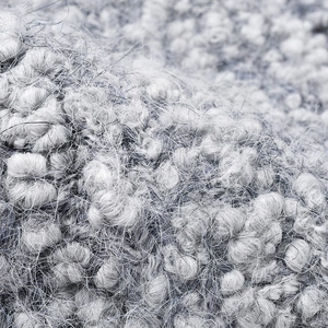 Close-up texture of a thick grey knitted beanie hat with soft wool blend fibers