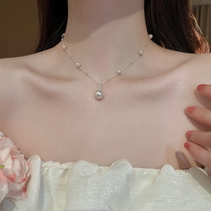 Detailed view of irregular pearl pendant necklace worn by model for an elegant vintage look