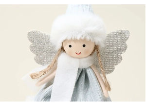 Close-up of plush Christmas angel ornament with silver wings and soft blue velvet dress
