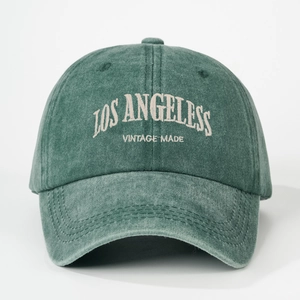 Detailed close-up of Los Angeles vintage embroidery on green washed cotton baseball cap