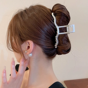 Pince à cheveux argentée avec strass roses présentée sur un mannequin en chignon