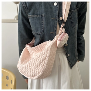 Detailed texture of pink puffy pleated shoulder bag with matching mini round coin purse charm