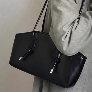Minimalist black PU leather shoulder bag with glossy finish and knot strap detail