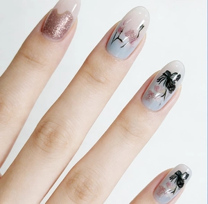 Macro shot of blue gradient press-on nails with floral patterns and glitter accent